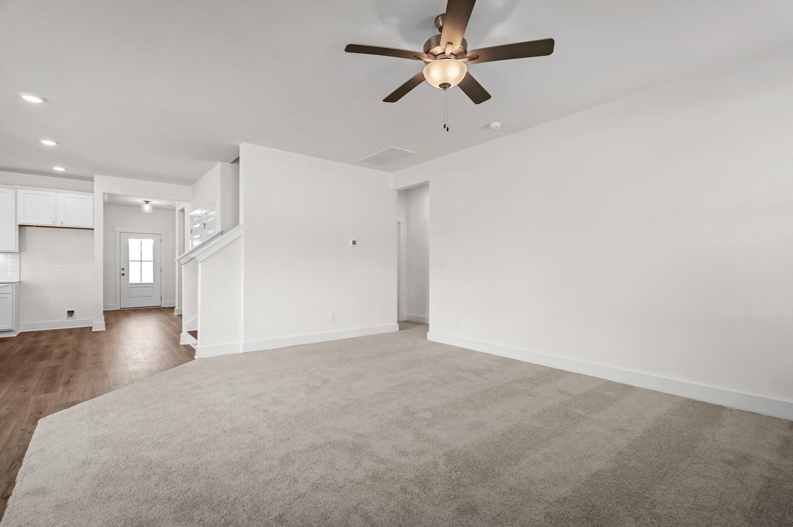 Spacious open-concept living area with ceiling fan in The Ash A floor plan at Woods Crossing, Gallatin, Tennessee.