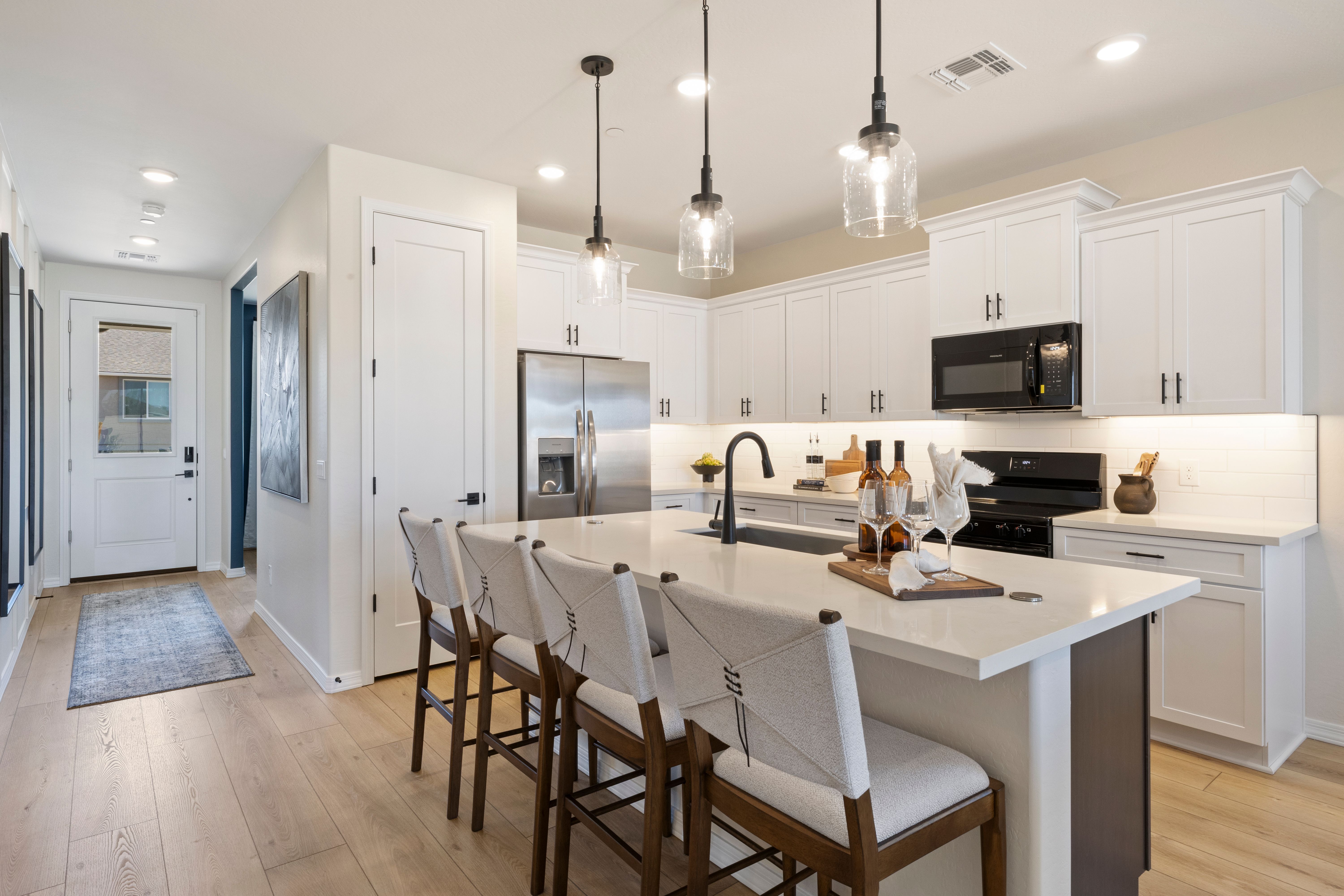 Spacious modern kitchen at Vineyards at Cottonwood in Cottonwood AZ with white cabinets, quartz island, and pendant lights