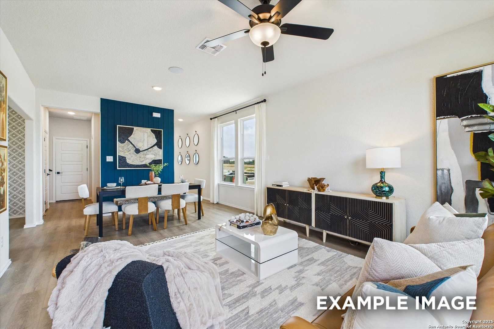 Elegant dining area with navy accent wall, wooden table, and large windows in Davidson Homes The Florence C, San Antonio