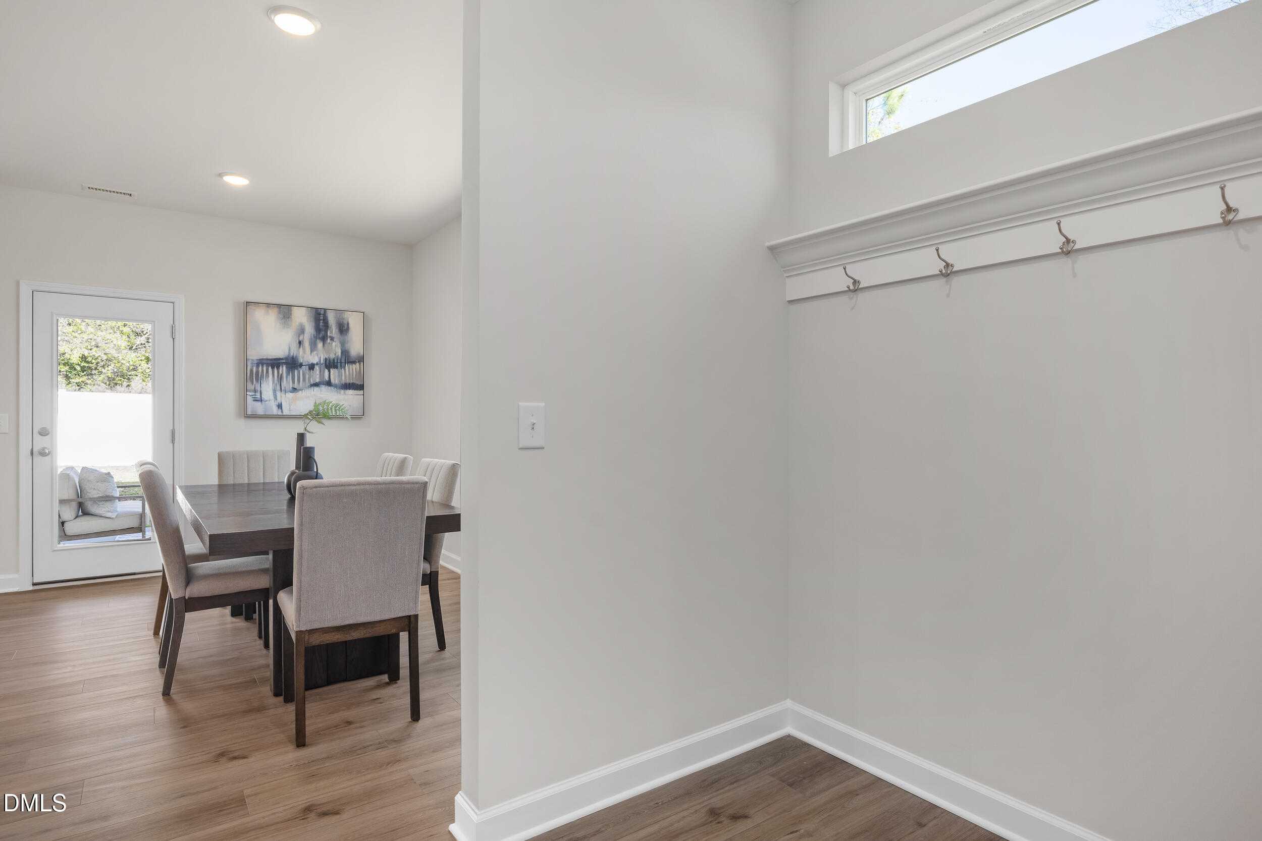 Elegant dining room with wooden table, upholstered chairs and abstract wall art in The Preston C by Davidson Homes, Gregory Village, Lillington, NC