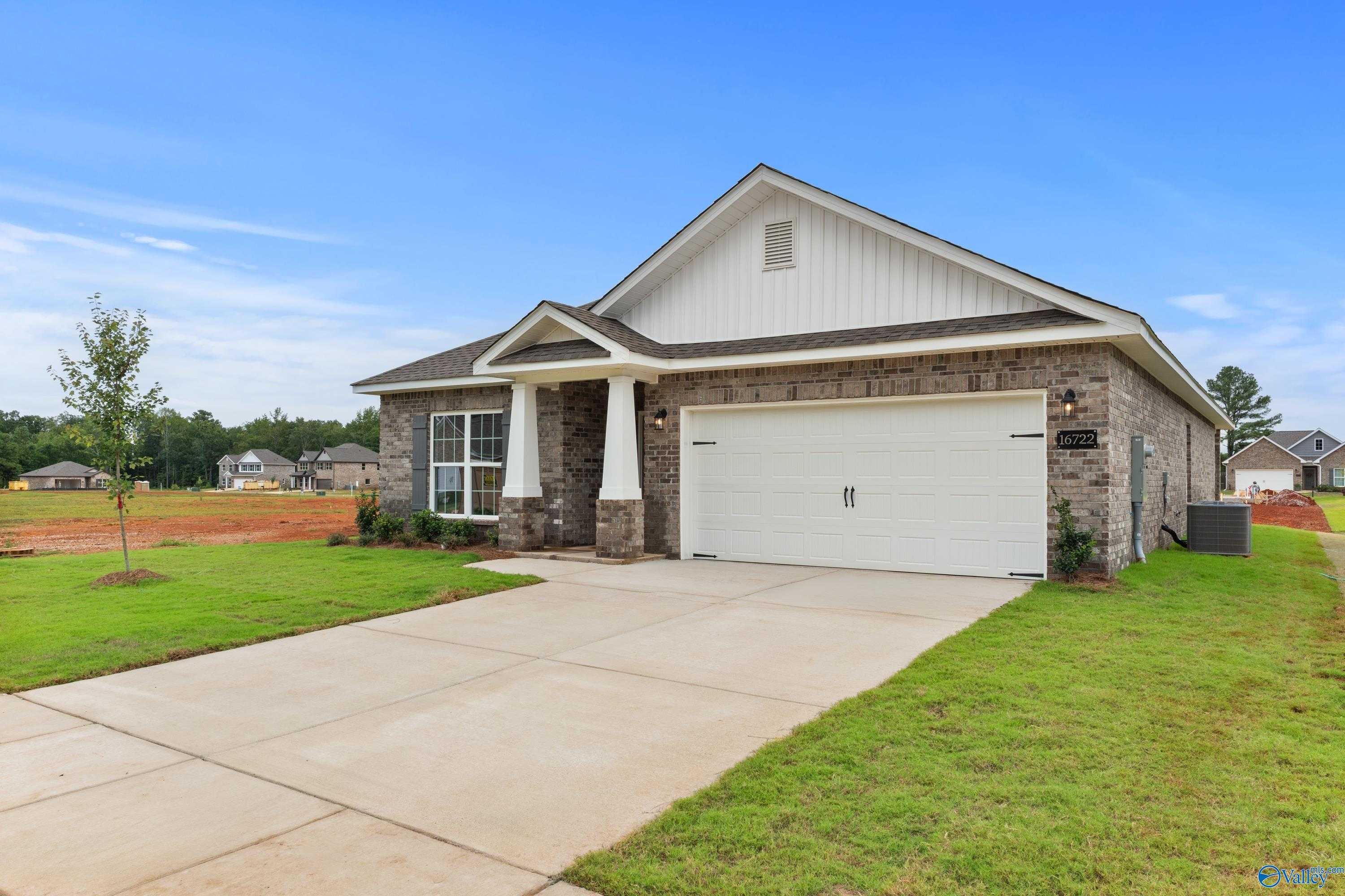 Modern 1-story brick home with 2-car garage, covered porch, and lush lawn in Ricketts Farm, Athens, Alabama by Davidson Homes The Daphne C