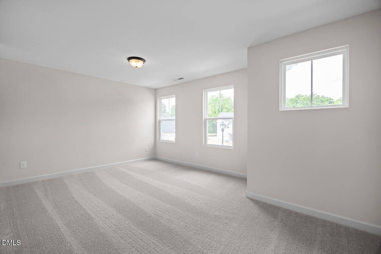 Bright, spacious bedroom with neutral carpet and natural light in The Willow B floor plan at Woodland Crossing, Zebulon.