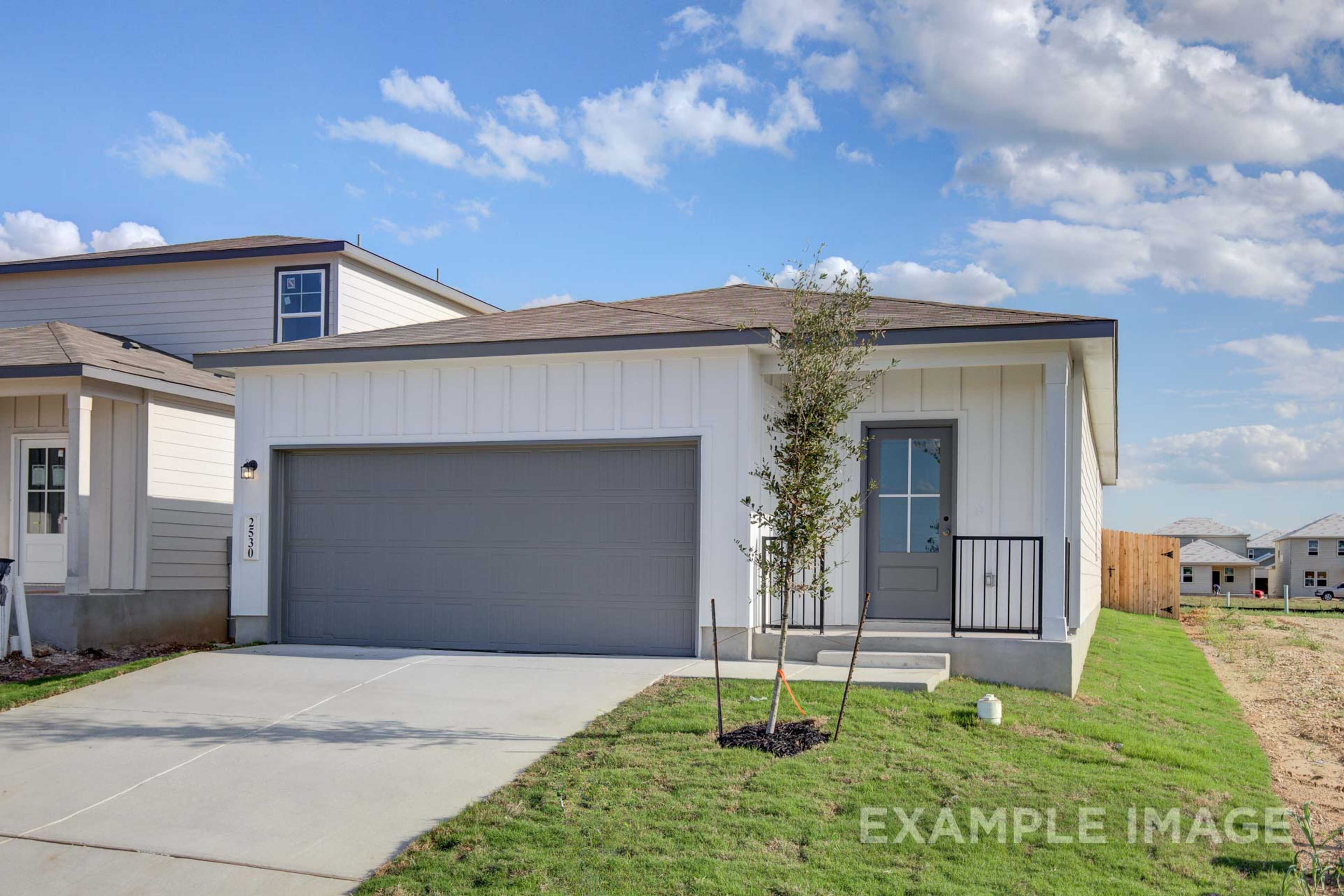 Modern single-story front elevation of The Frio A home design by Davidson Homes, white board-and-batten siding, two-car garage, San Antonio