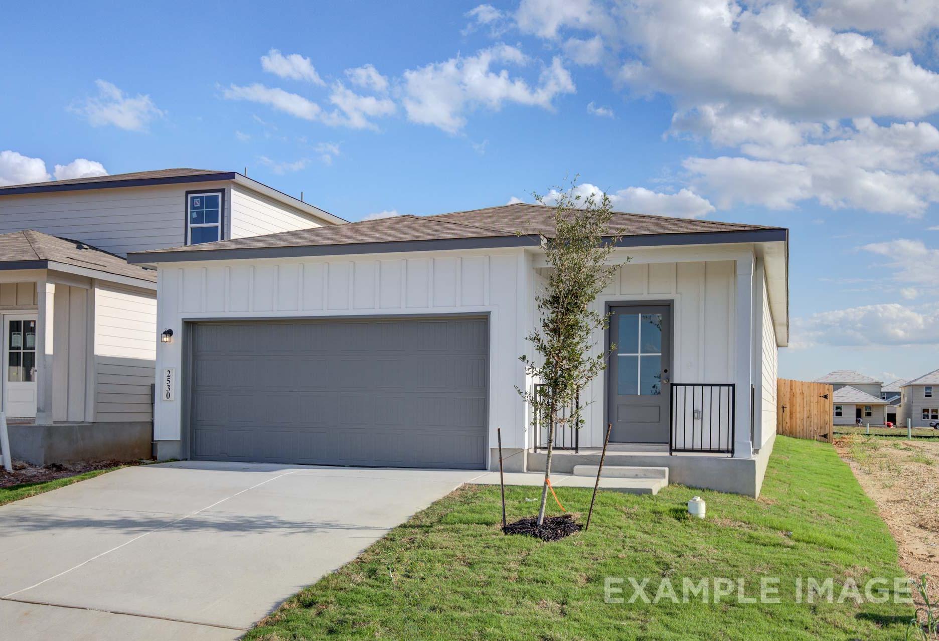 Modern single-story front elevation of The Frio A home design by Davidson Homes, white board-and-batten siding, two-car garage, San Antonio
