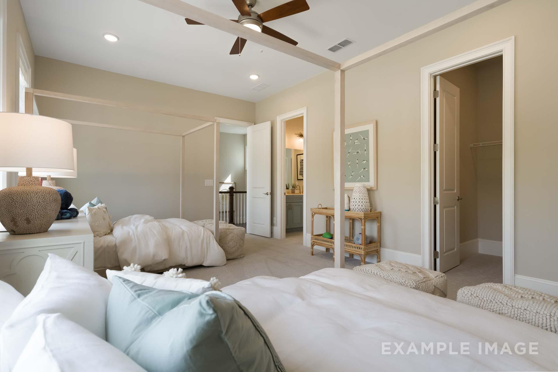 Spacious master bedroom in The Seaside C featuring canopy bed, neutral tones, ceiling fan, and en-suite bath access