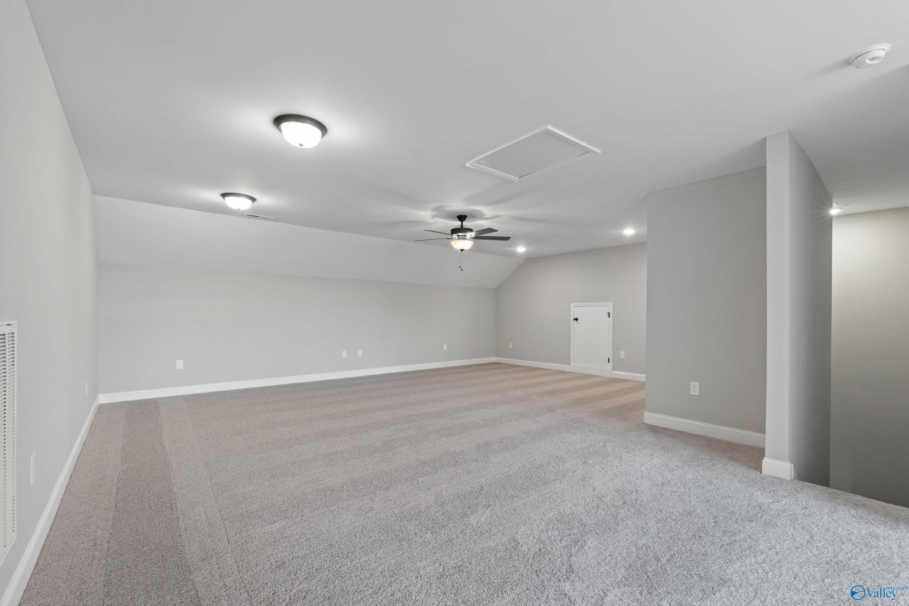 Spacious empty bonus room with gray carpet, ceiling fan, recessed lights in Davidson Homes The Rockford with Bonus, Toney, AL