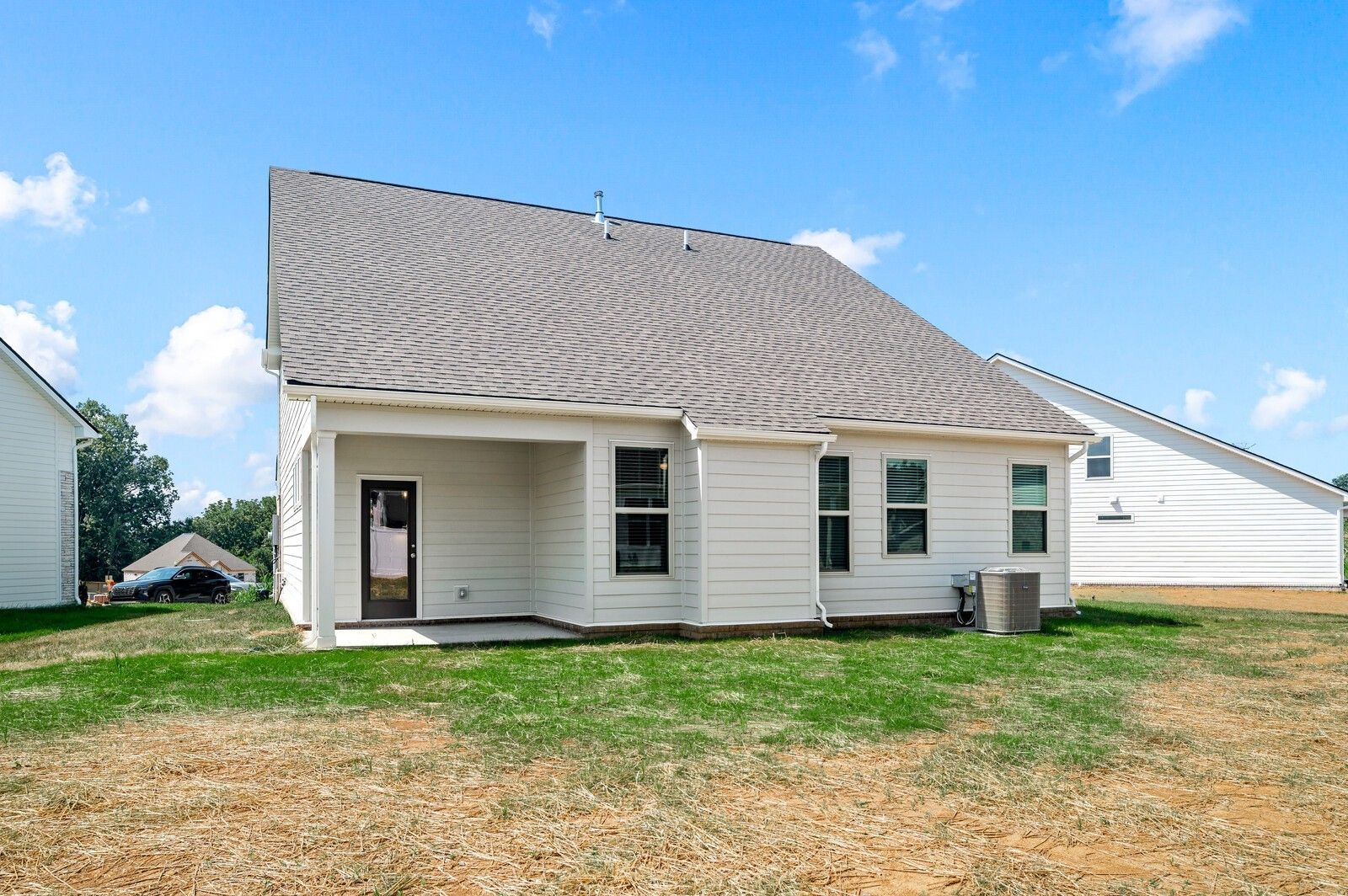Back exterior view of The Ash A floor plan by Davidson Homes in Woods Crossing, Gallatin, Tennessee with covered patio.