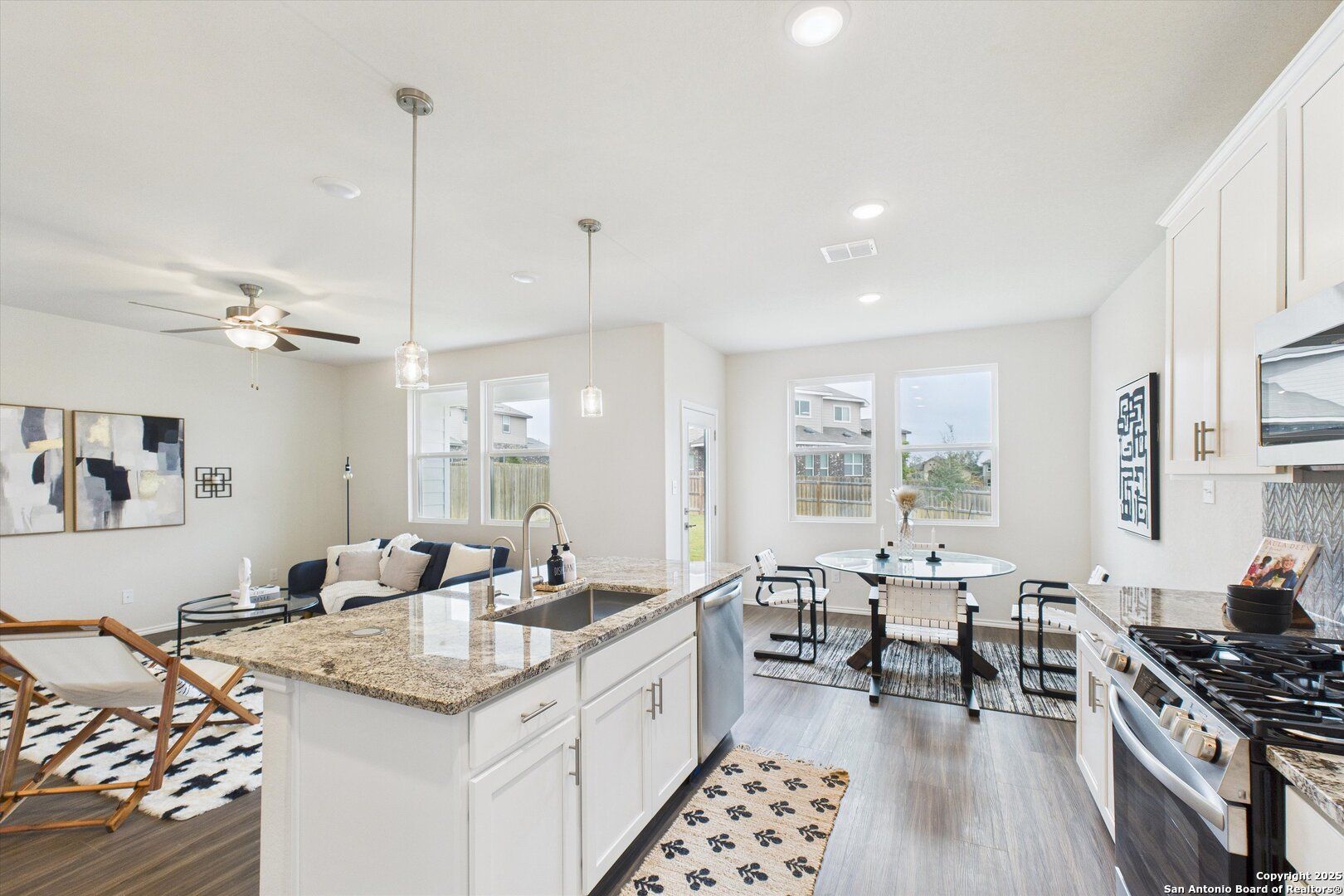 Modern open-concept kitchen with granite island, stainless appliances, dining nook in Davidson Homes The Asheville K, Bricewood, San Antonio