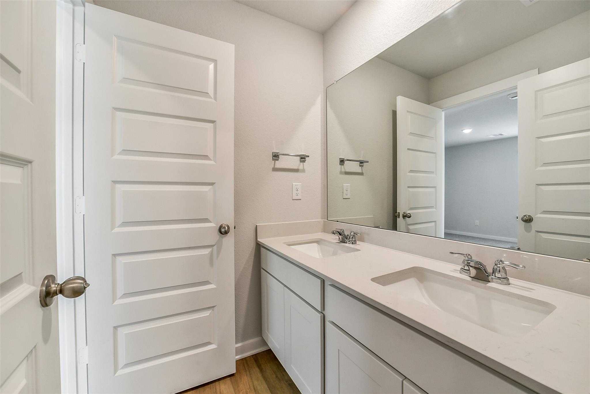 Modern double vanity with white shaker cabinets and quartz counters in The Trinity F master bath, Magnolia, Texas