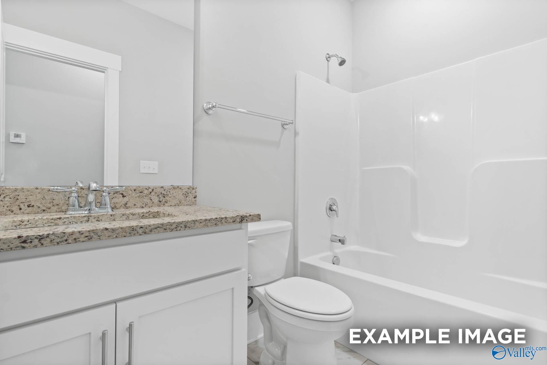 Modern master bathroom featuring granite vanity, deep soaking tub, and glass shower in Davidson Homes The Rockford, Meridianville