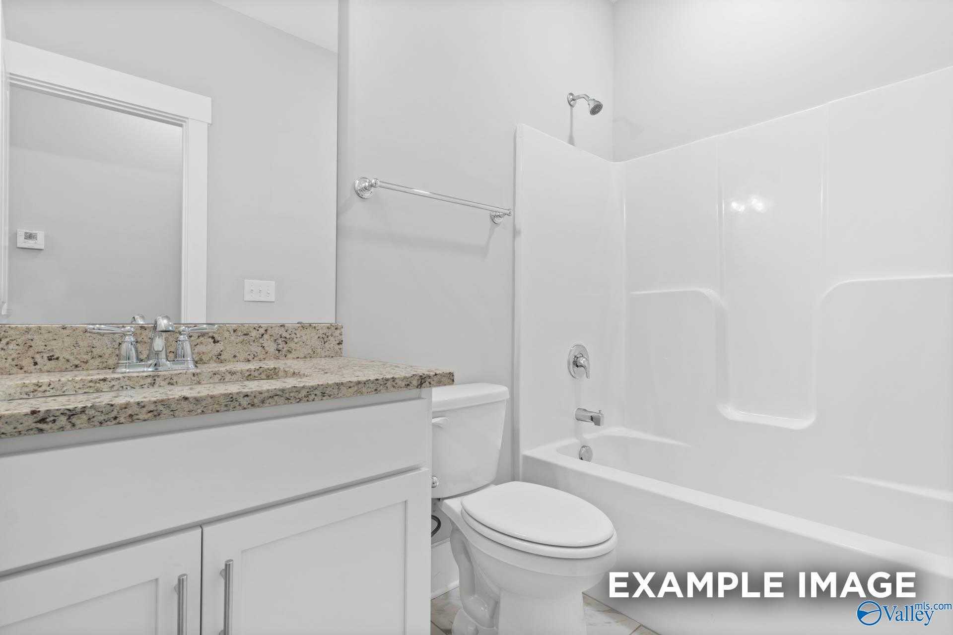 Modern master bathroom featuring granite vanity, deep soaking tub, and glass shower in Davidson Homes The Rockford, Meridianville