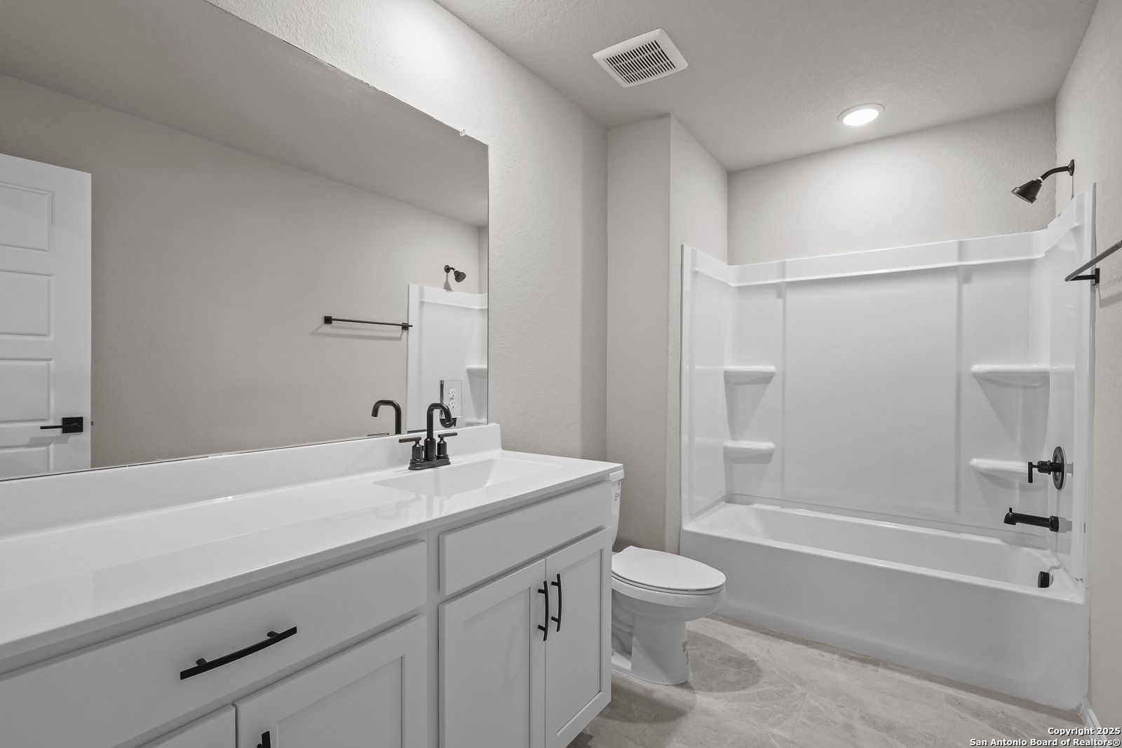 Modern secondary bathroom with white double vanity, tub-shower combo, and neutral tones in Davidson Homes The Murray J, San Antonio