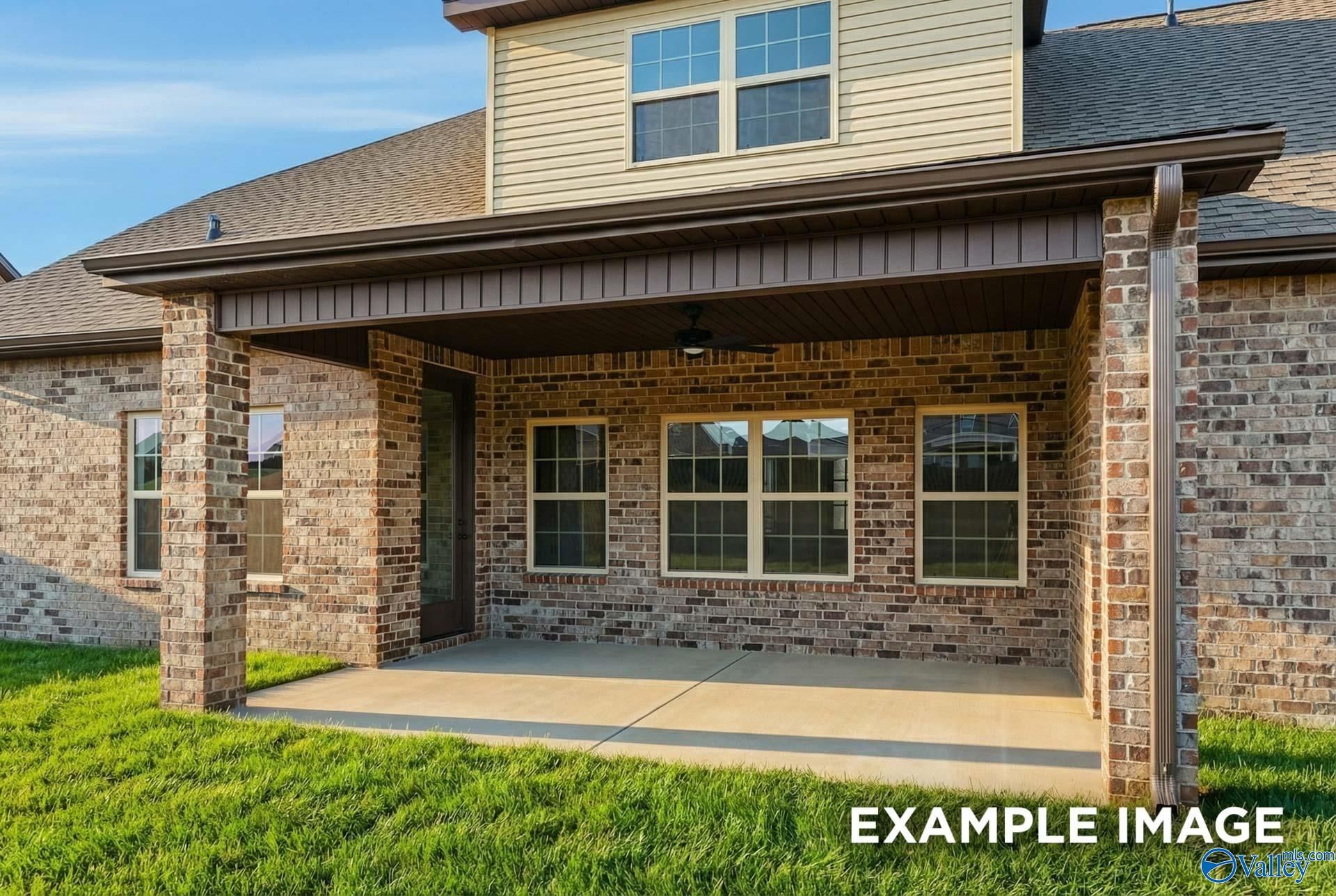 Two-story brick home with covered front porch, beige siding, and large windows in Hollon Meadow, Decatur, Alabama