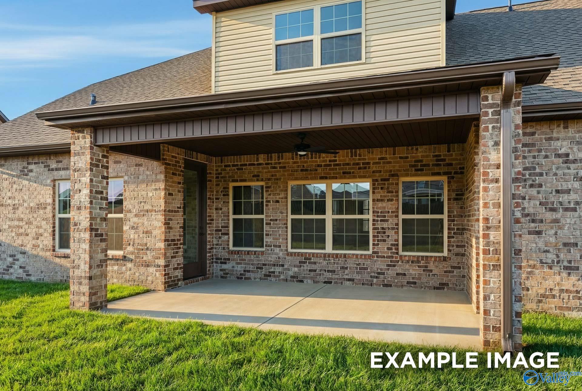 Two-story brick home with covered front porch, beige siding, and large windows in Hollon Meadow, Decatur, Alabama