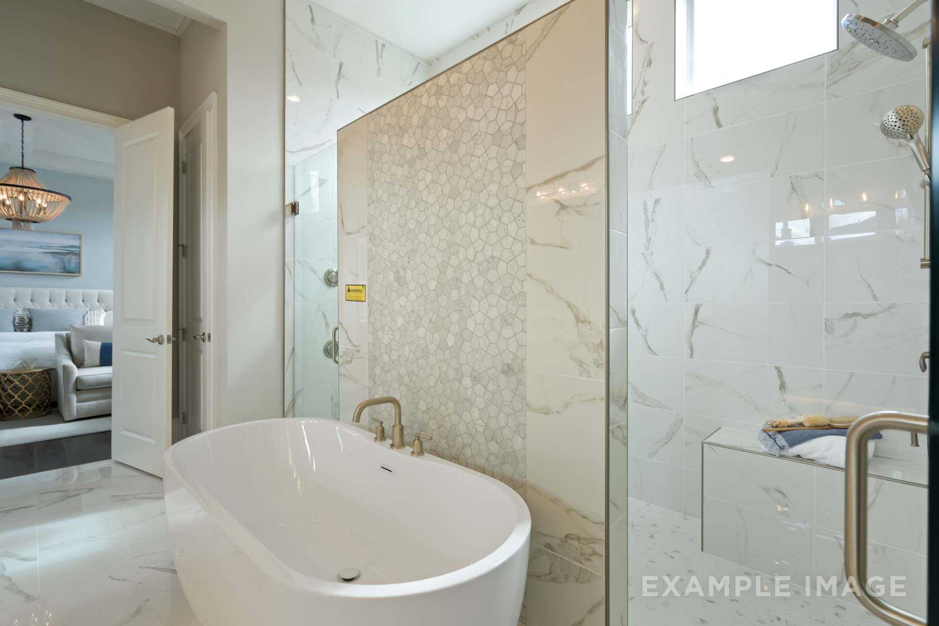 Spacious master bathroom in The Seaside home design featuring freestanding tub, glass shower, and chandelier lighting