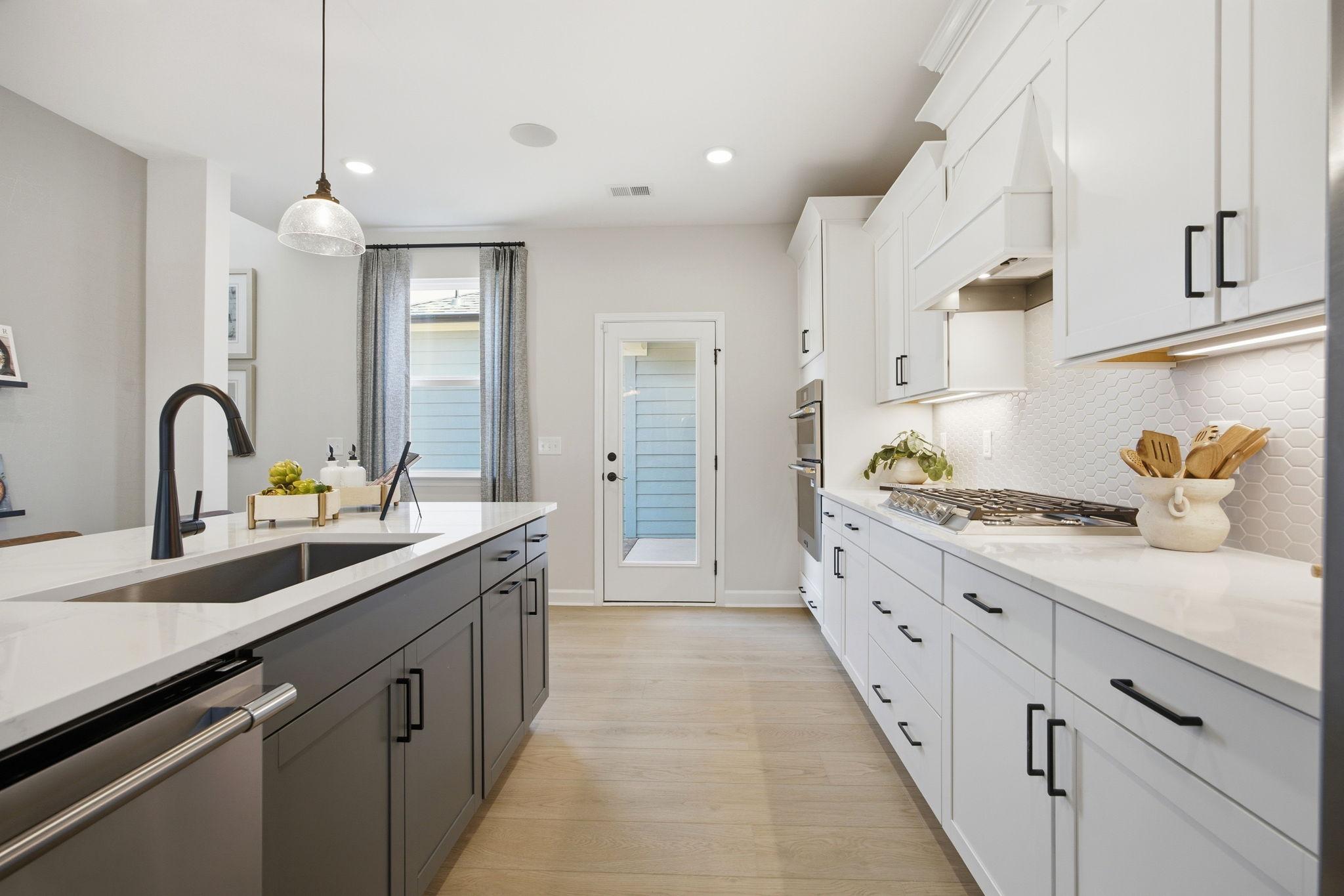 Modern gourmet kitchen in The Burke C featuring a two-tone island, white cabinetry, and high-end finishes in Knightdale.