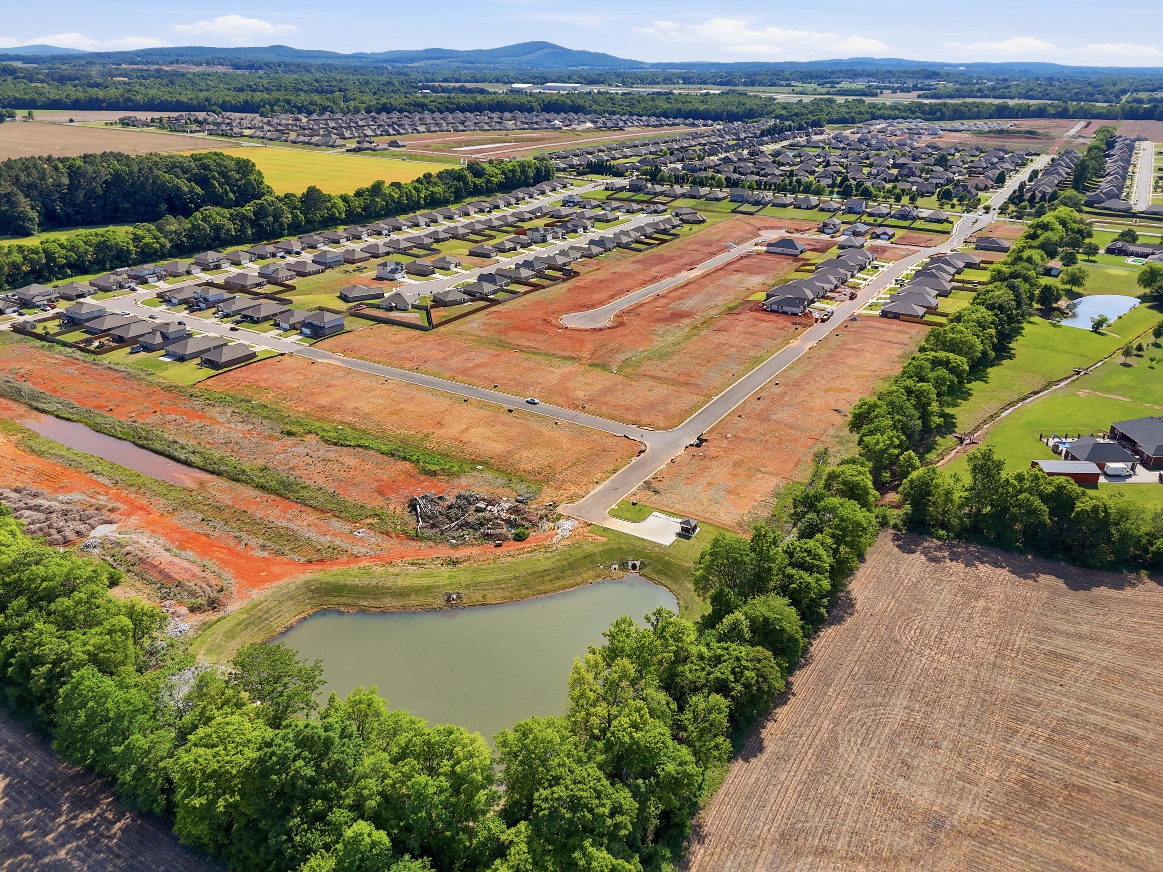 Aerial view of Lynn Meadows community in Meridianville, AL featuring new Davidson Homes construction site and scenic pond.