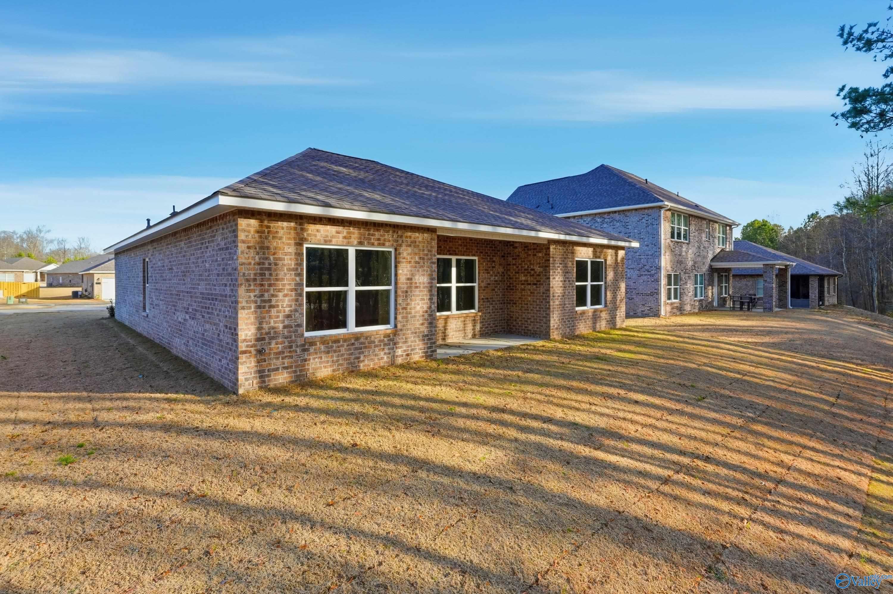 Single-story brick home with 2-car garage, covered patio, and spacious backyard in The Highlands, Arab, Alabama