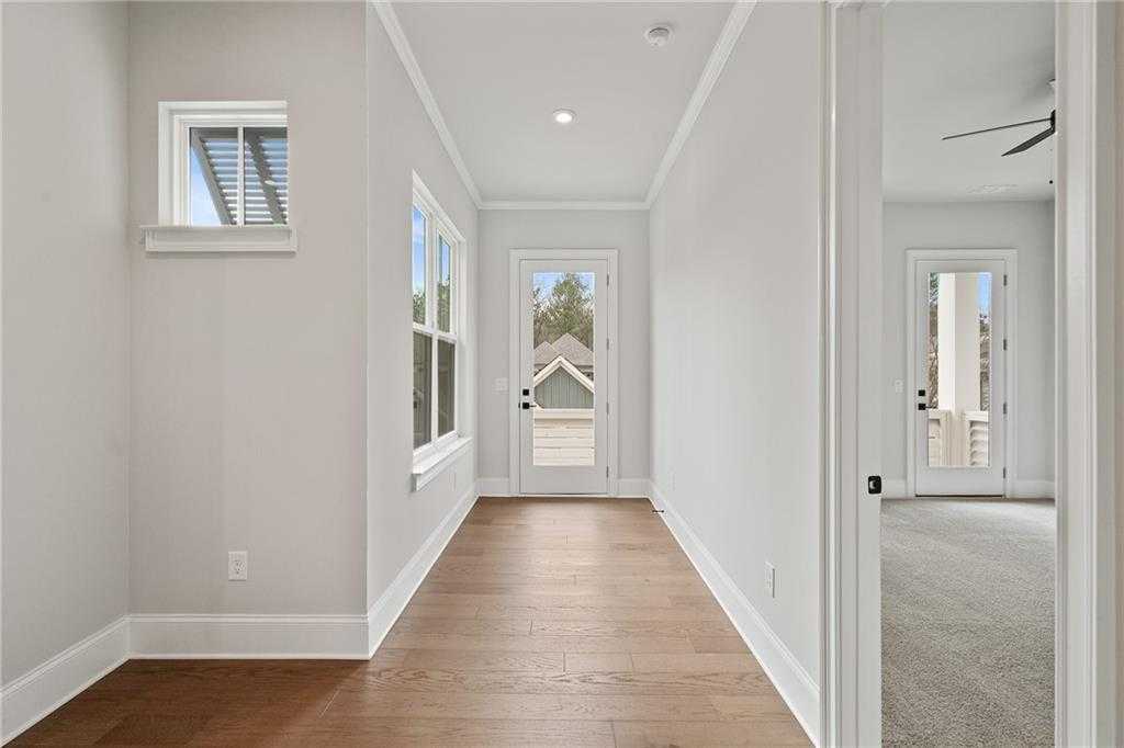 Bright hallway with hardwood floors, light gray walls, large windows, and French doors in Davidson Homes The Seaside B, Woodstock, GA