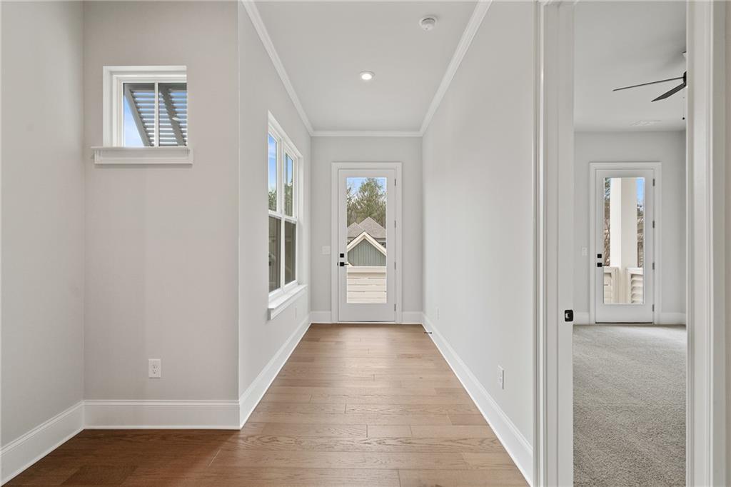 Bright hallway with hardwood floors, light gray walls, large windows, and French doors in Davidson Homes The Seaside B, Woodstock, GA