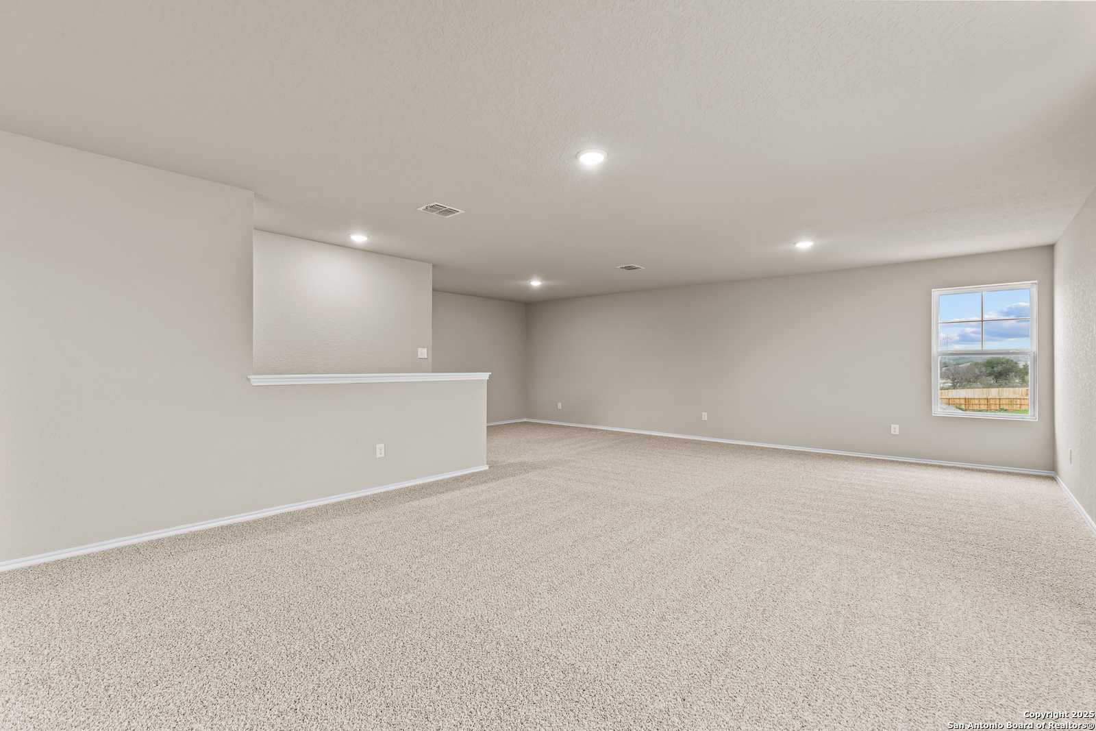 Spacious upstairs bonus room with built-in serving bar and large window in Davidson Homes The Douglas F, Royal Crest, San Antonio