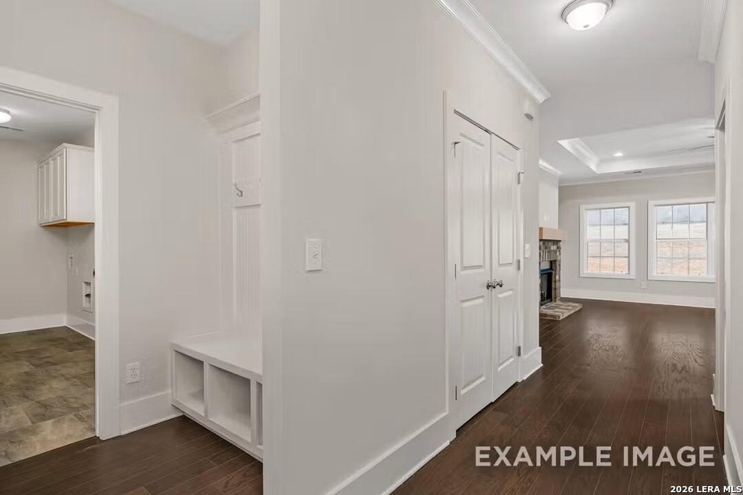 Bright entry hallway with built-in coat closet bench and laundry room access in Davidson Homes The Rockford F, Castroville, Texas