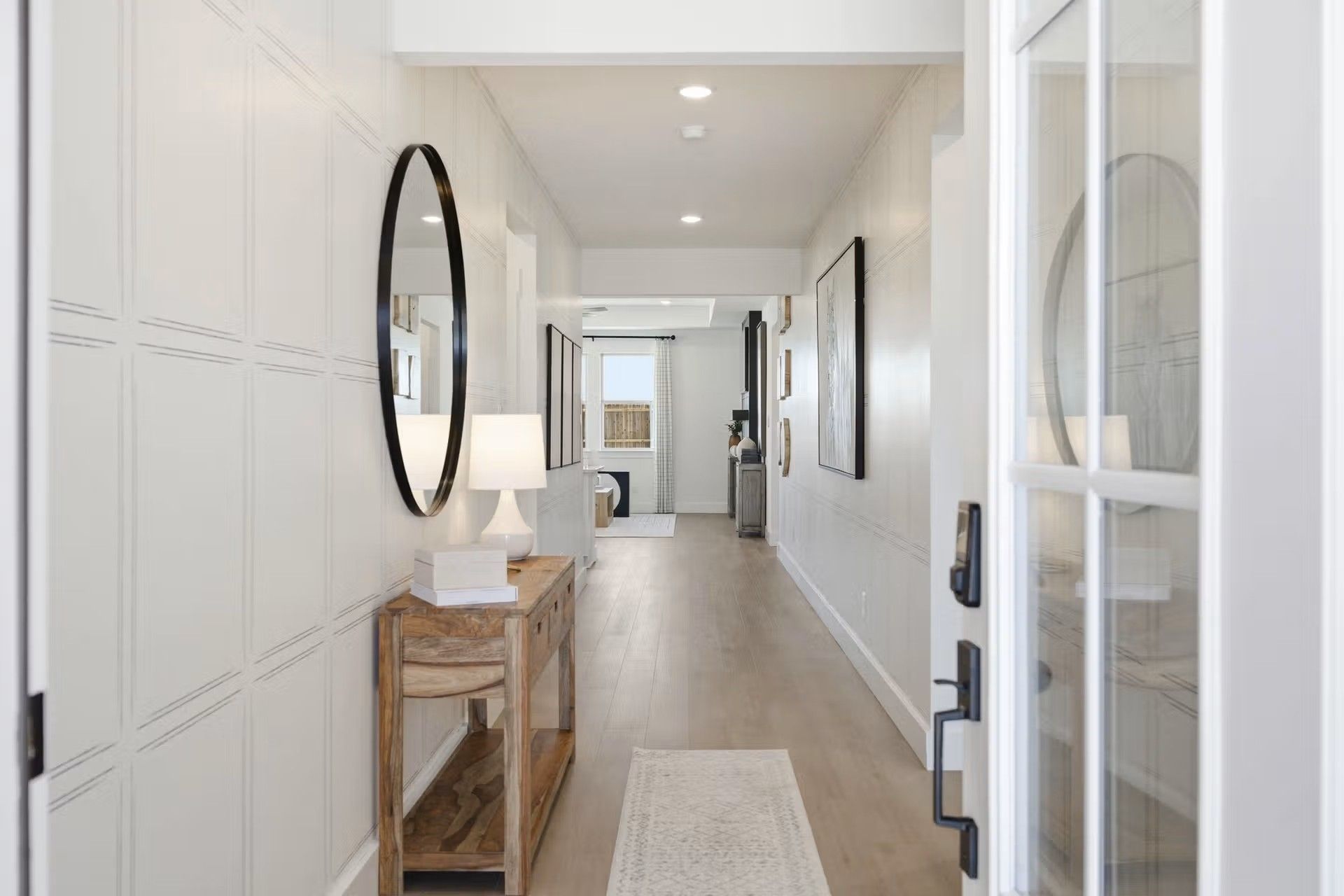 Bright, welcoming entryway with wood console and wainscoting in The Laurel O floor plan by Davidson Homes in Royse City, TX.