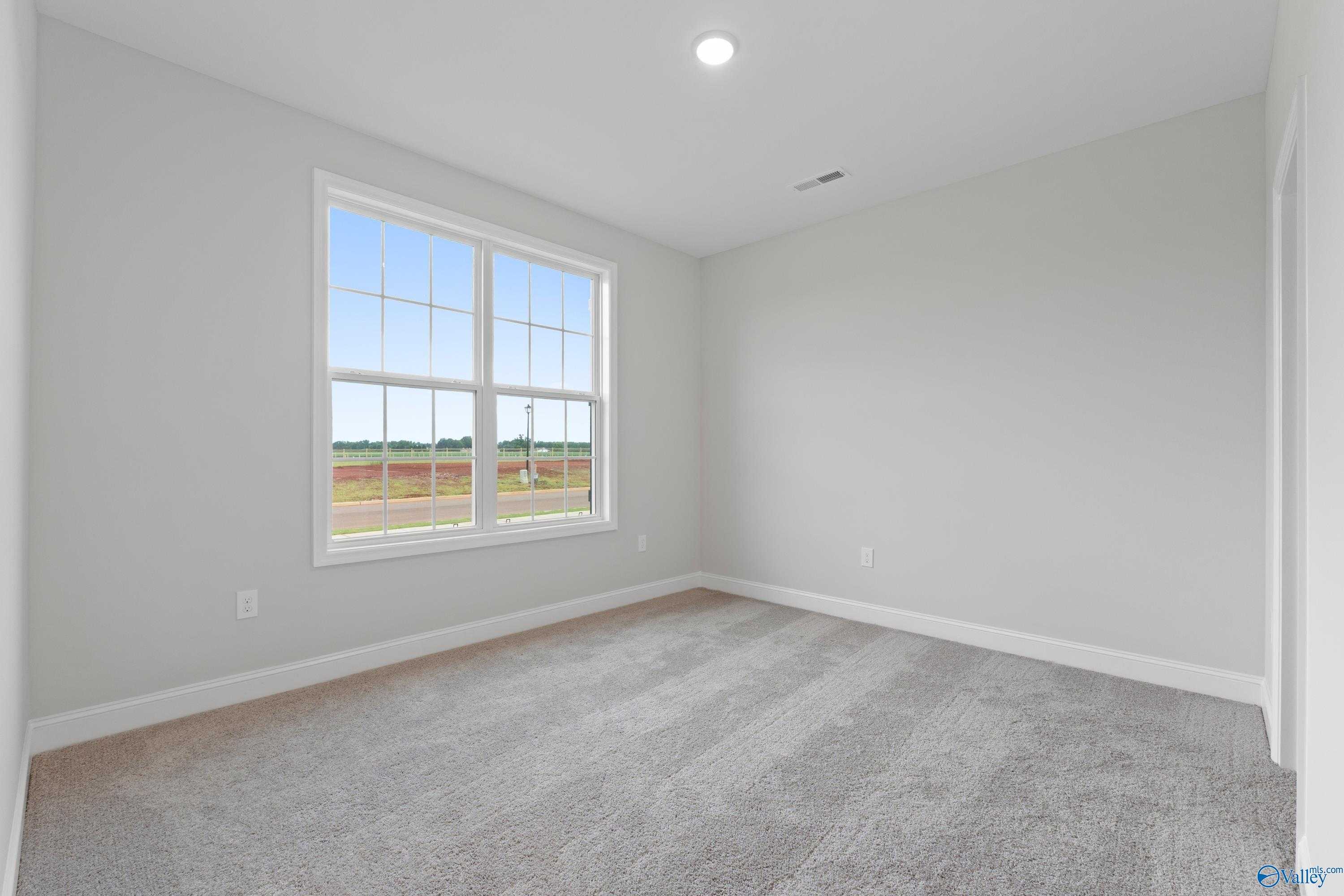 Bright secondary bedroom with large windows overlooking fields in Davidson Homes The Rockford B, Toney, Alabama
