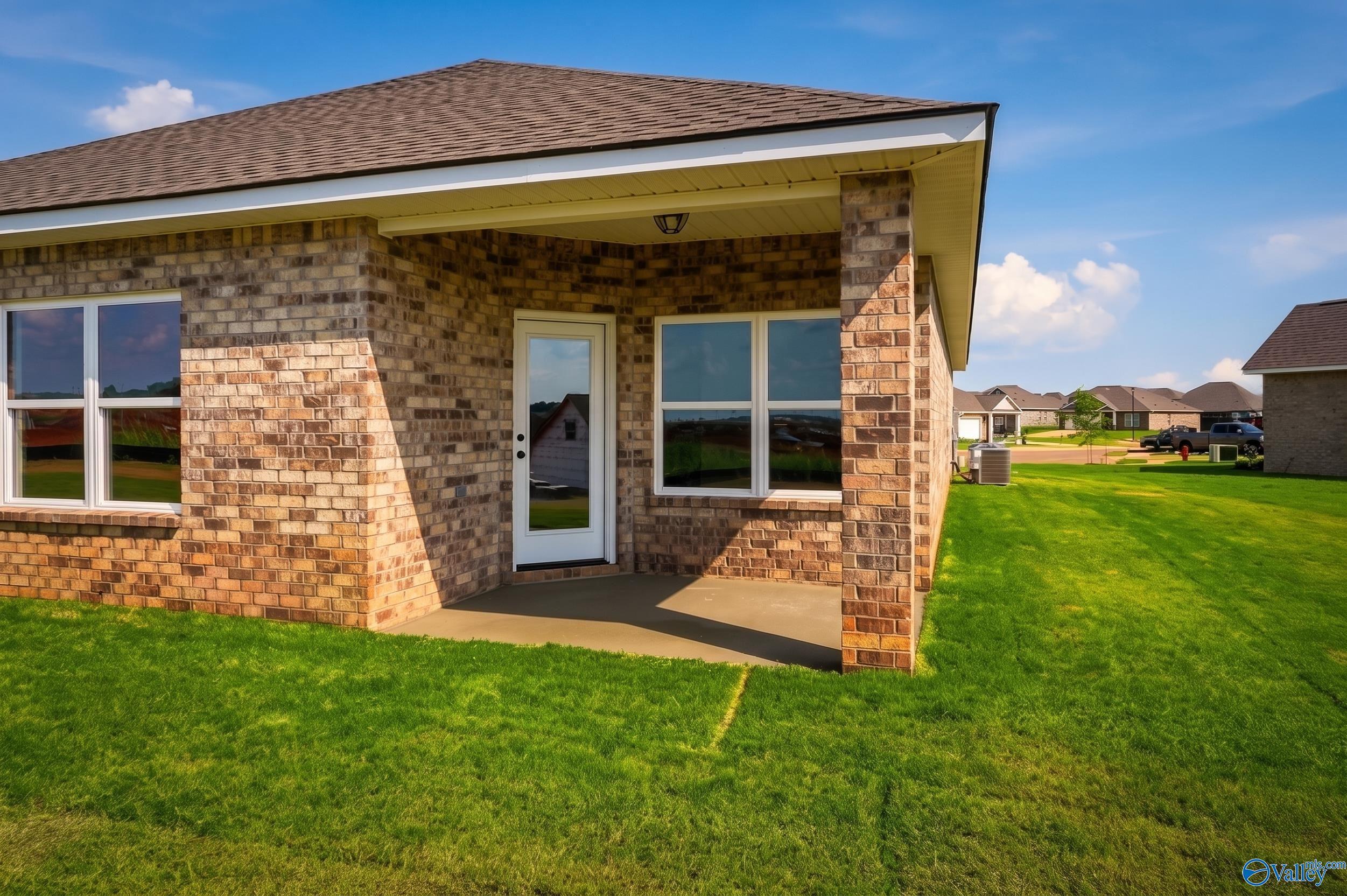 Brick exterior of The Daphne D floor plan with covered patio and backyard in Creekside, Harvest, Alabama.