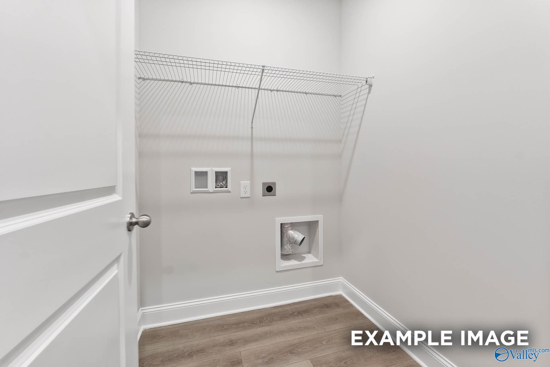 Spacious laundry room with wire shelving and washer dryer hookups in The Asheville V by Davidson Homes, Athens, Alabama