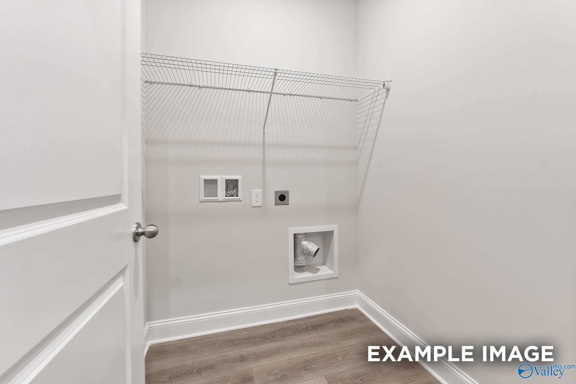 Functional laundry room with wire shelving and washer-dryer hookups in Davidson Homes The Asheville, Huntsville, Alabama