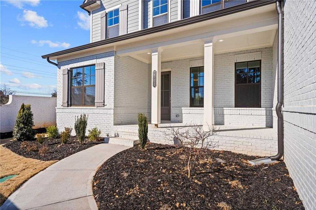 Elegant two-story white brick home with covered front porch, columns, and landscaped walkway in Tanglewood, East Cobb, Georgia - The Arlington A by Davidson Homes