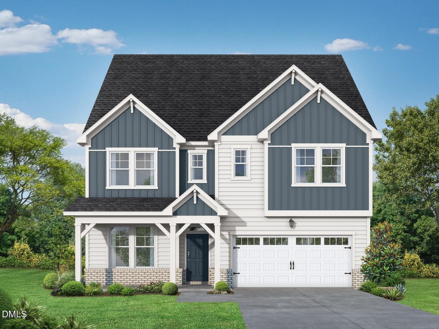 Modern three-story navy blue home with white trim, two-car garage, and covered front porch in Wake Forest, North Carolina