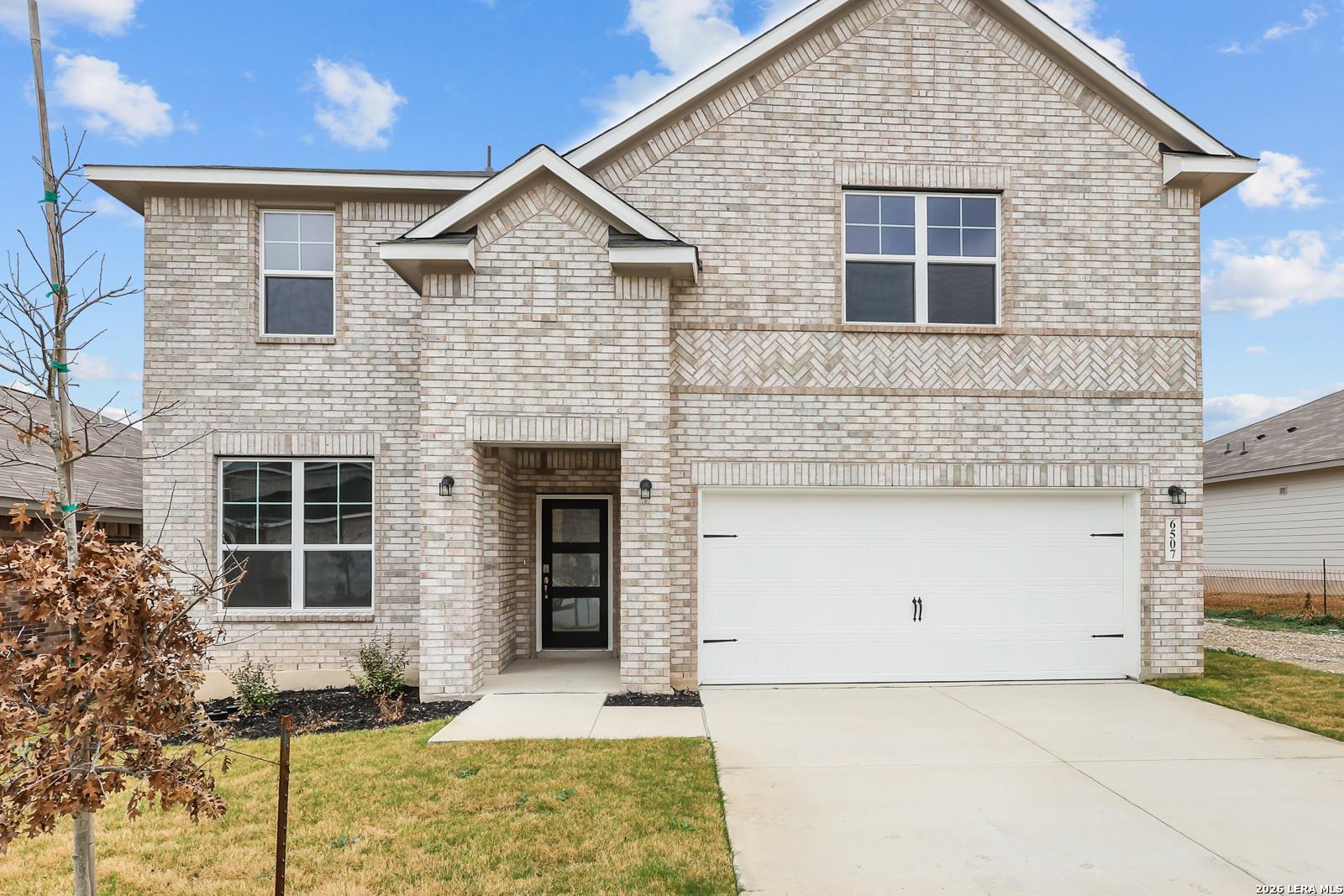Two-story brick home with 2-car garage, gabled roof, and landscaped driveway in Royal Crest, San Antonio, Texas - Davidson Homes Sequoia A