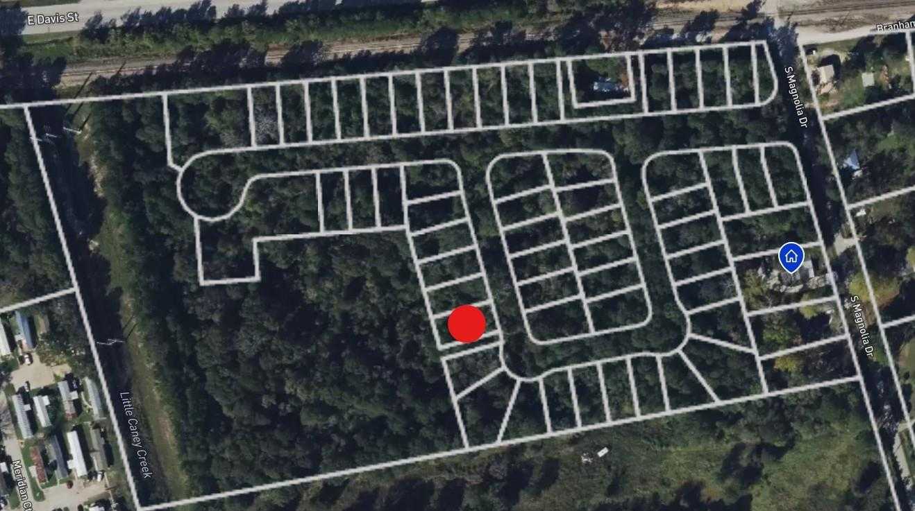 Aerial view of wooded Caney Creek Place neighborhood in Conroe, Texas, with outlined lots and red marker for Davidson Homes' 4-bedroom Colorado F site