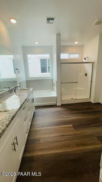 Modern primary bathroom with soaking tub, glass walk-in shower, and granite vanity in The Summit A home, Prescott, Arizona.