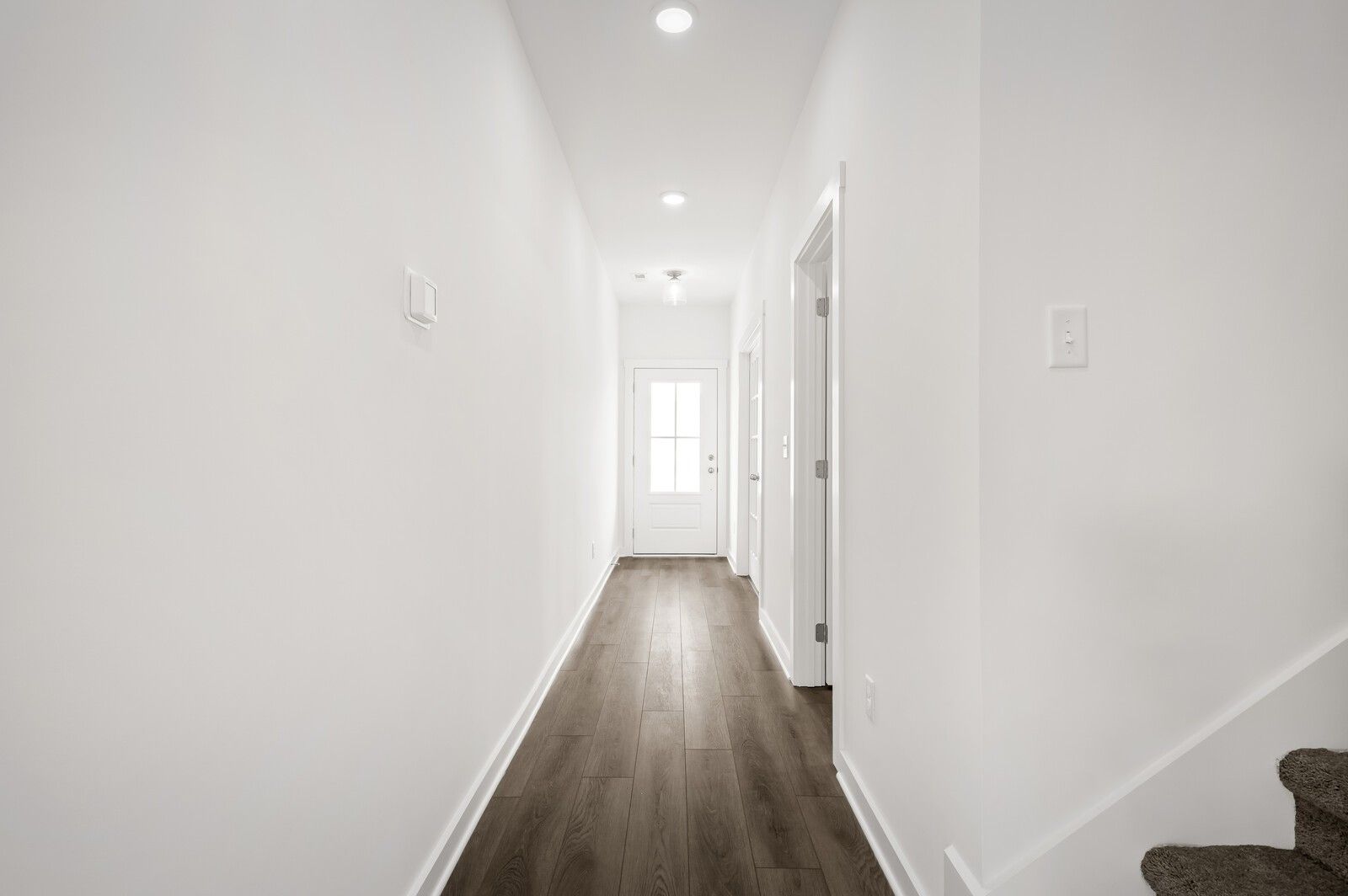 Bright, modern hallway with wood-style flooring in The Logan C floor plan at Calista Farms, White House, Tennessee.