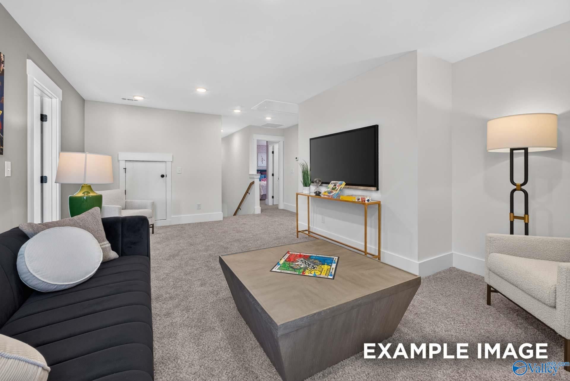 Spacious upstairs loft with wall-mounted TV, plush seating, and game table in Davidson Homes Ashport K, Forest Glen, Hazel Green