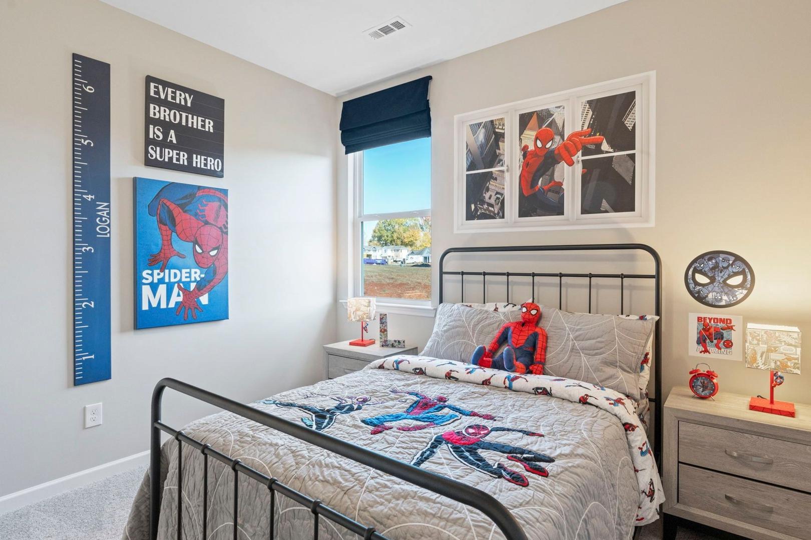 Cozy Spider-Man themed boy's bedroom in The Phoenix A with twin bed, growth chart, posters, and nightstand