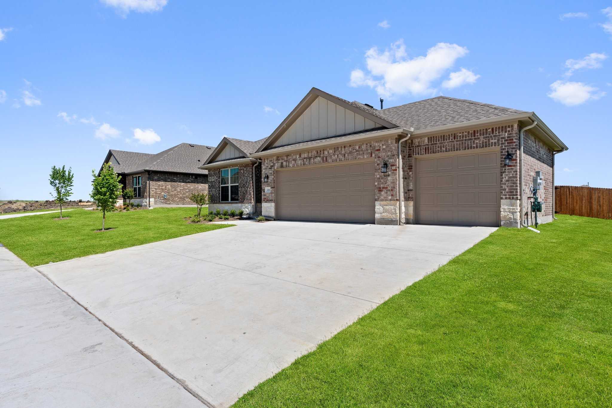Modern single-story brick home with 3-car garage, wide driveway, and lush green lawn in Waverly Estates, Josephine, Texas