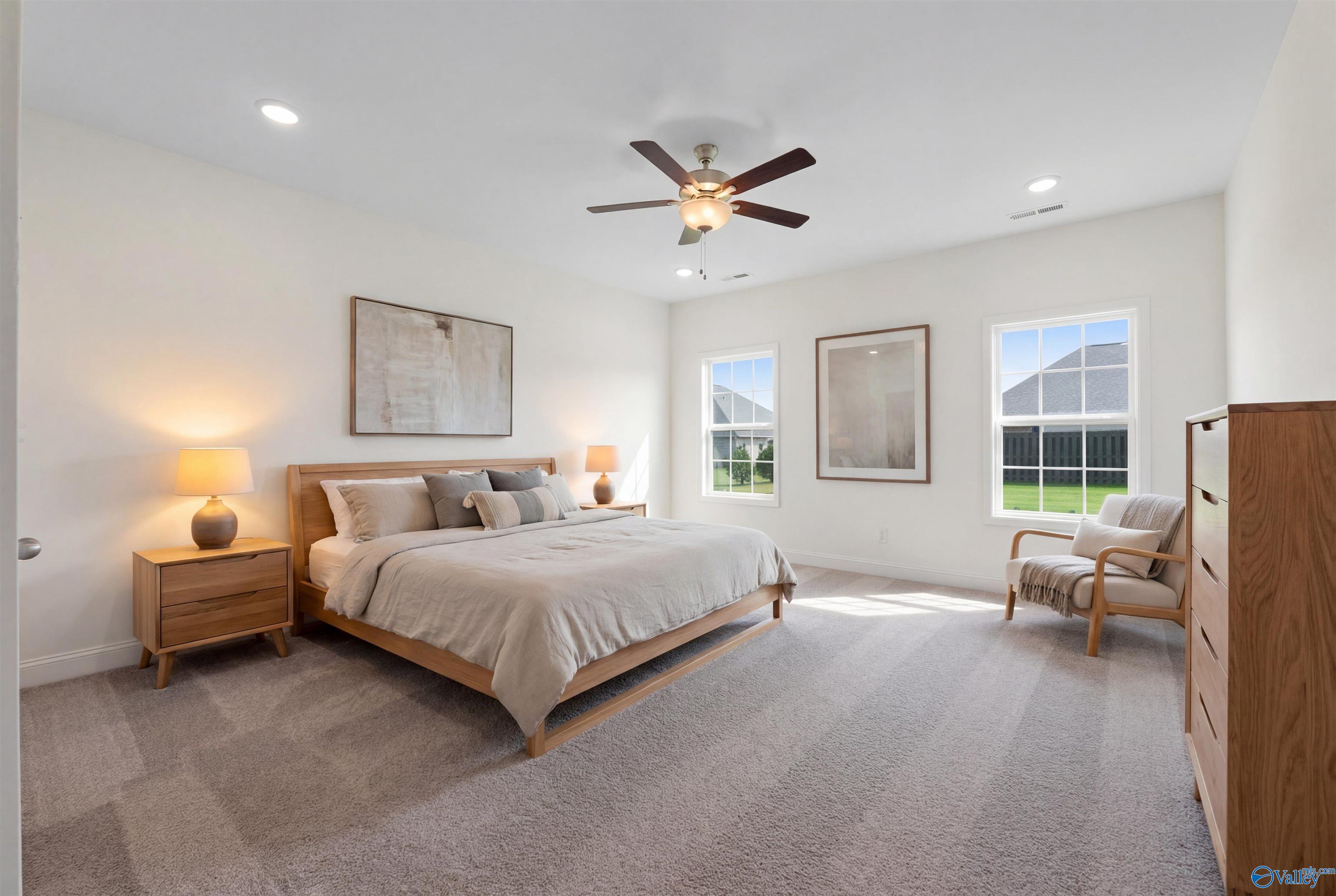 Serene master bedroom with king bed, ceiling fan, large windows, and neutral decor in Davidson Homes The Rockford B with Bonus, Toney, Alabama