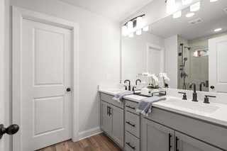 Spacious master bathroom in The Washington H townhome featuring double vanity, gray shaker cabinets, frameless mirrors, and walk-in shower