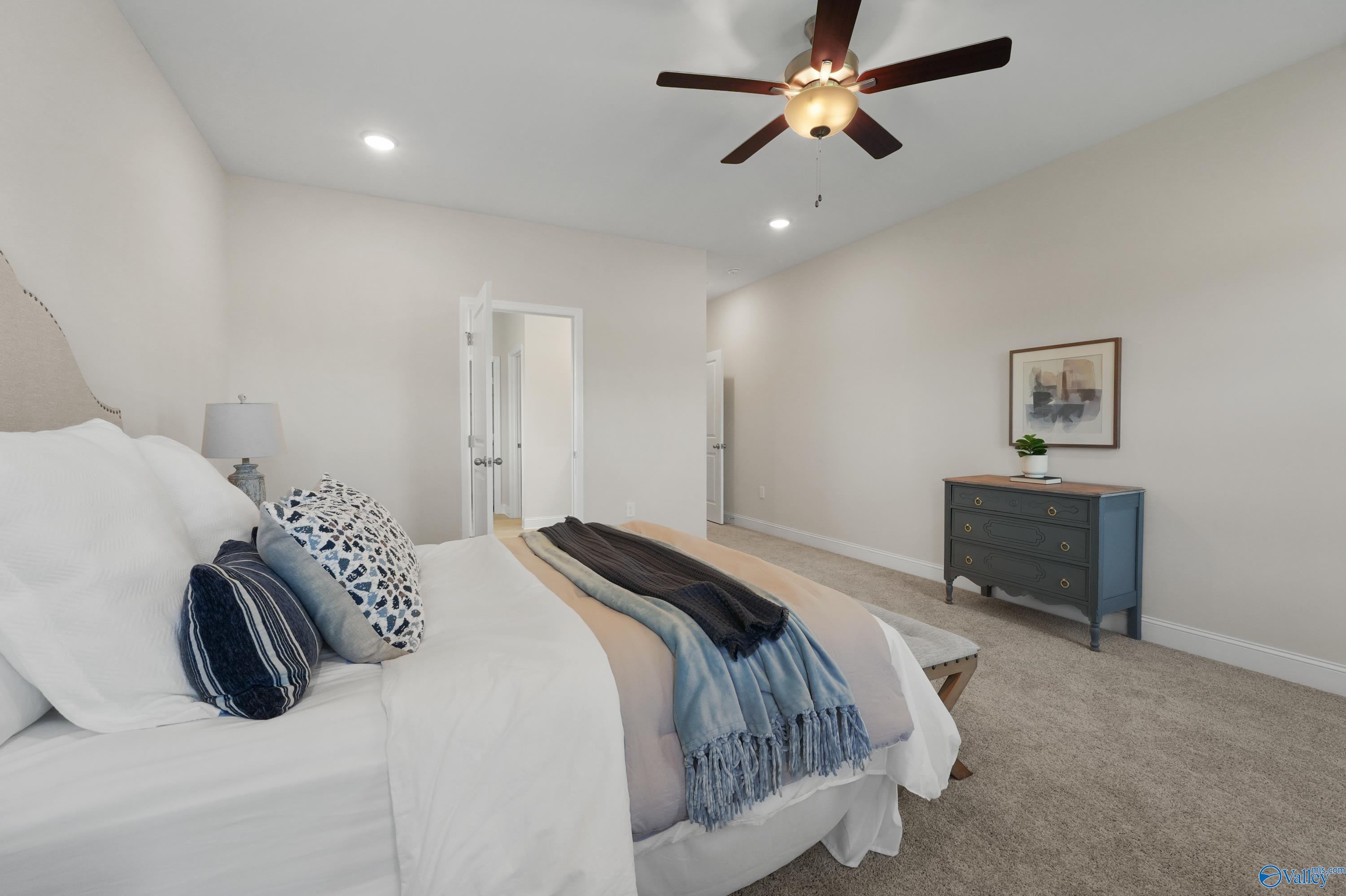 Cozy master bedroom with king bed, ceiling fan, dresser, and artwork in Davidson Homes The Rockford B with Bonus, Toney, Alabama
