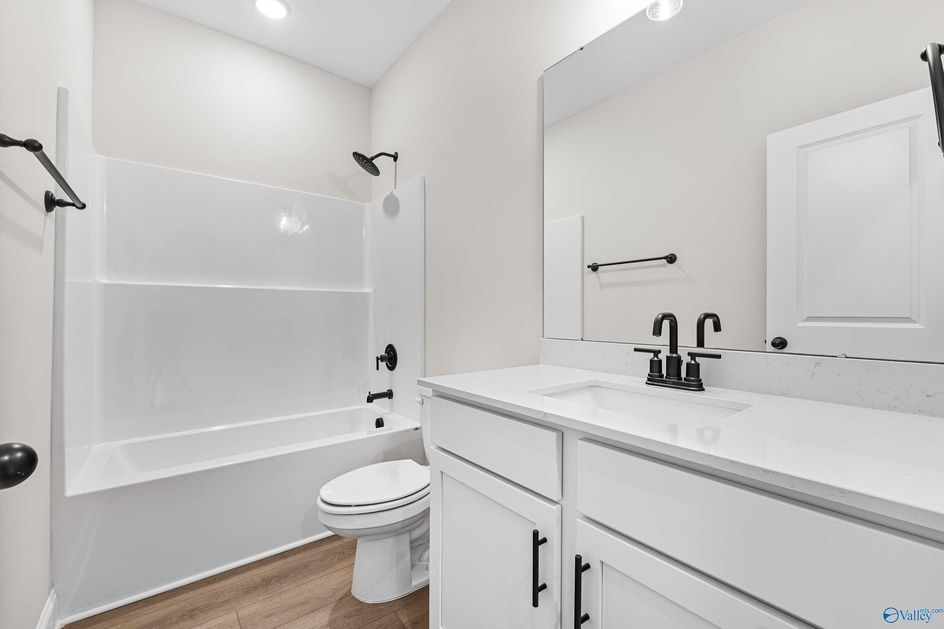 Modern bathroom with white subway tile shower-tub combo, double sink vanity, black fixtures in Davidson Homes The Franklin B, Hazel Green, AL