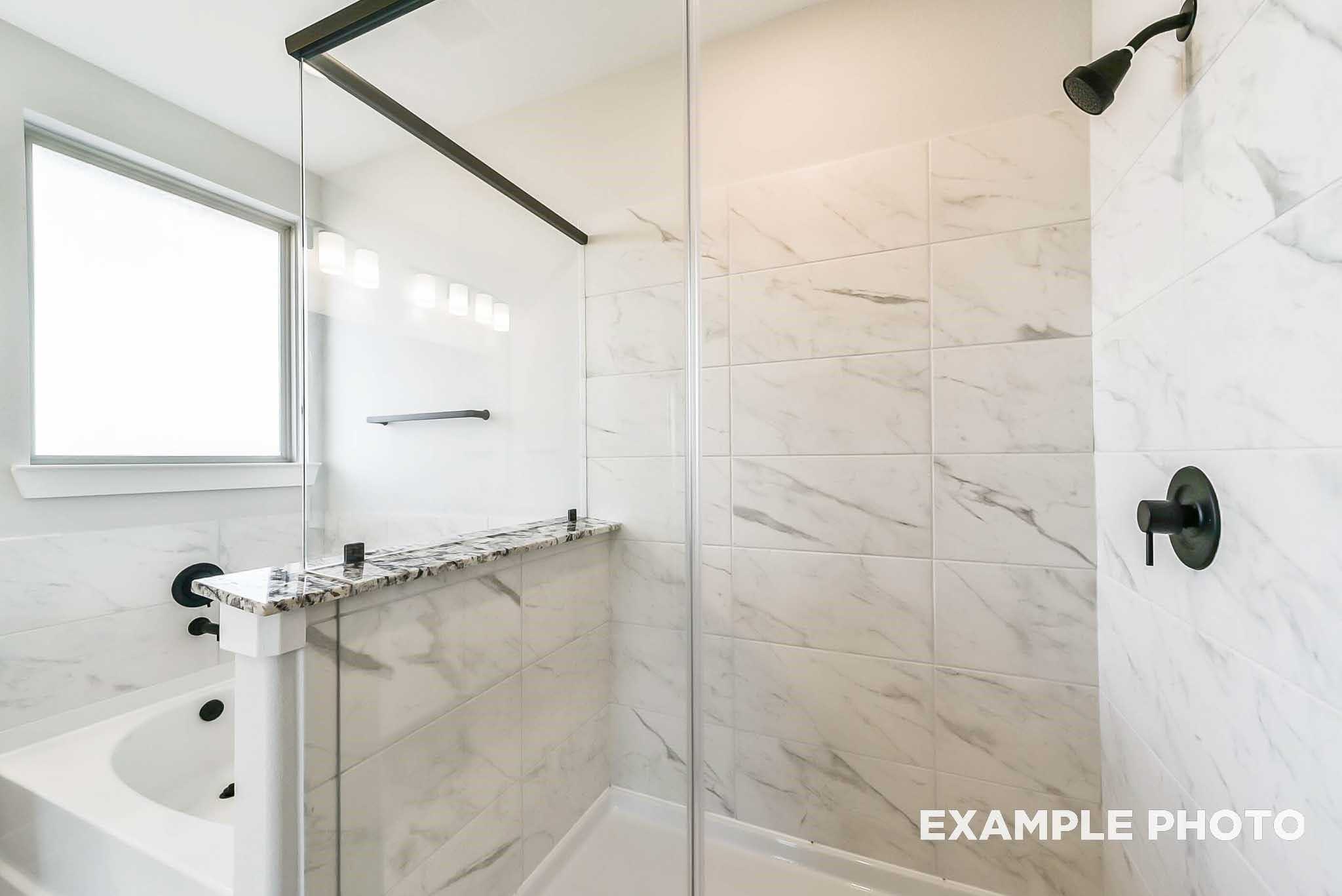 Modern master bathroom with glass shower enclosure, subway tile walls, granite vanity in Davidson Homes The Philip C, Rosharon, Texas