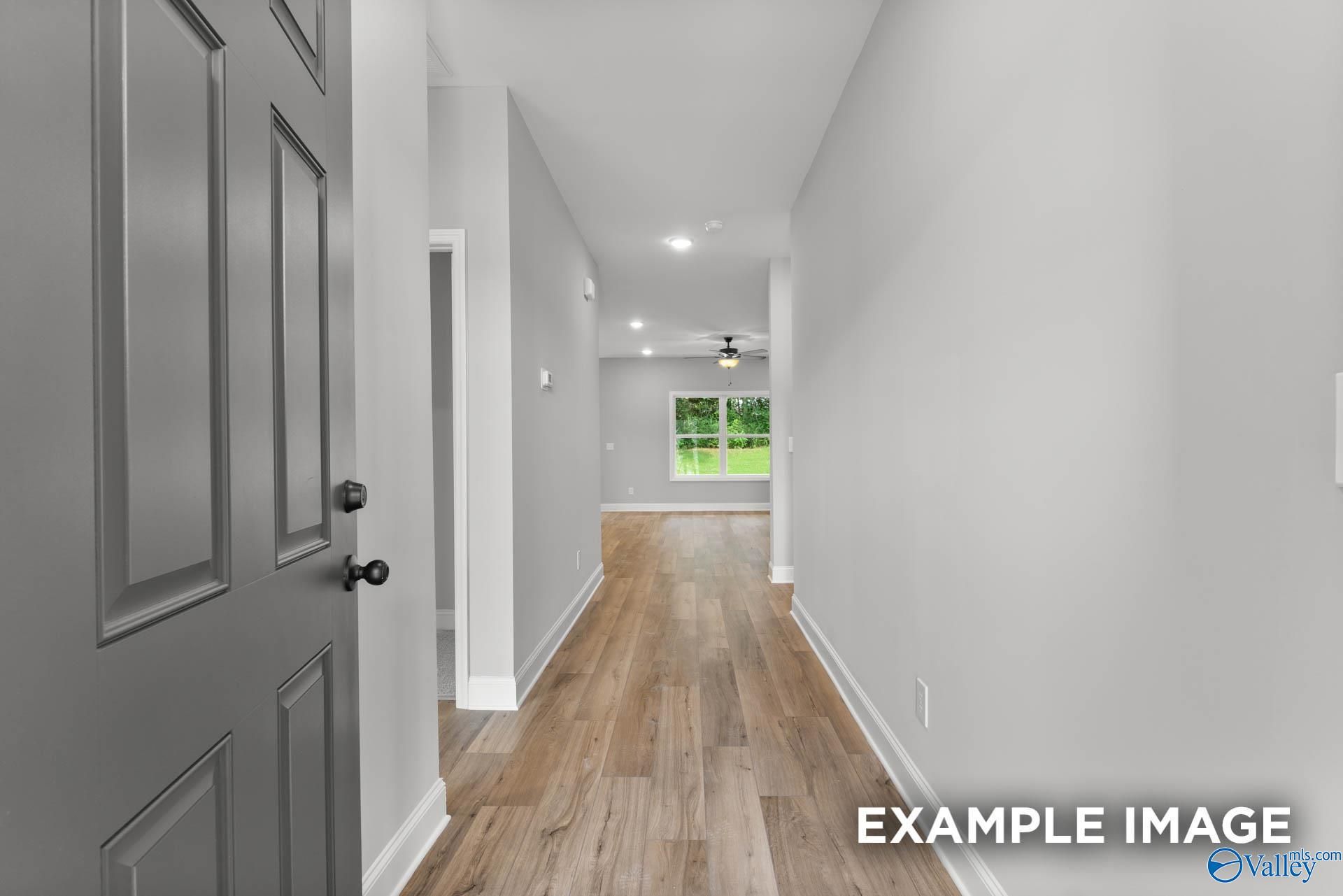 Bright hallway with gray walls, hardwood floors, and ceiling fan in The Asheville C 3-bedroom home by Davidson Homes, Hazel Green, Alabama