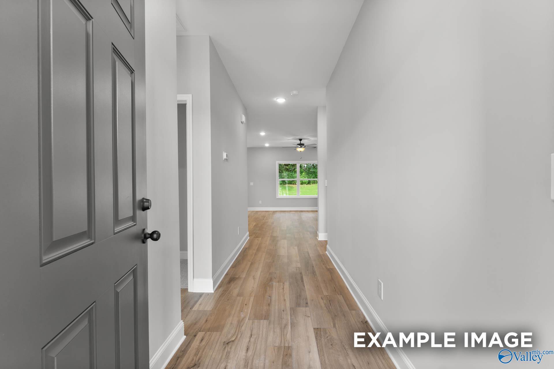 Bright hallway with gray walls, hardwood floors, and ceiling fan in The Asheville C 3-bedroom home by Davidson Homes, Hazel Green, Alabama