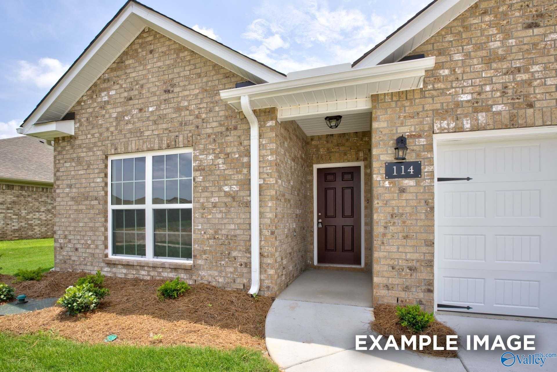 Beige brick one-story home with 2-car garage, dark wood door numbered 114, and landscaped front yard in Walker's Hill, Meridianville, Alabama