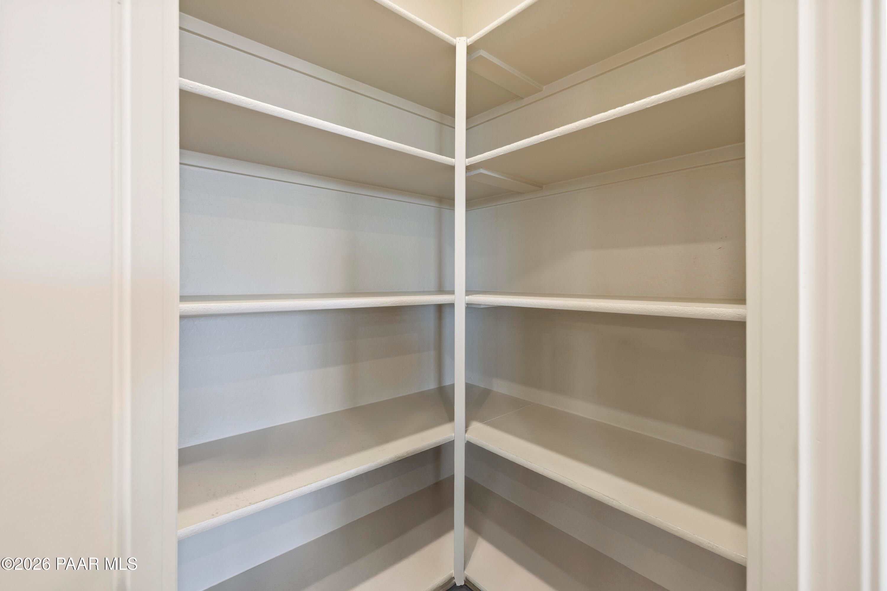 Spacious walk-in pantry with white shelving in The Harmony A floor plan at Pronghorn Ranch, Prescott Valley, Arizona.