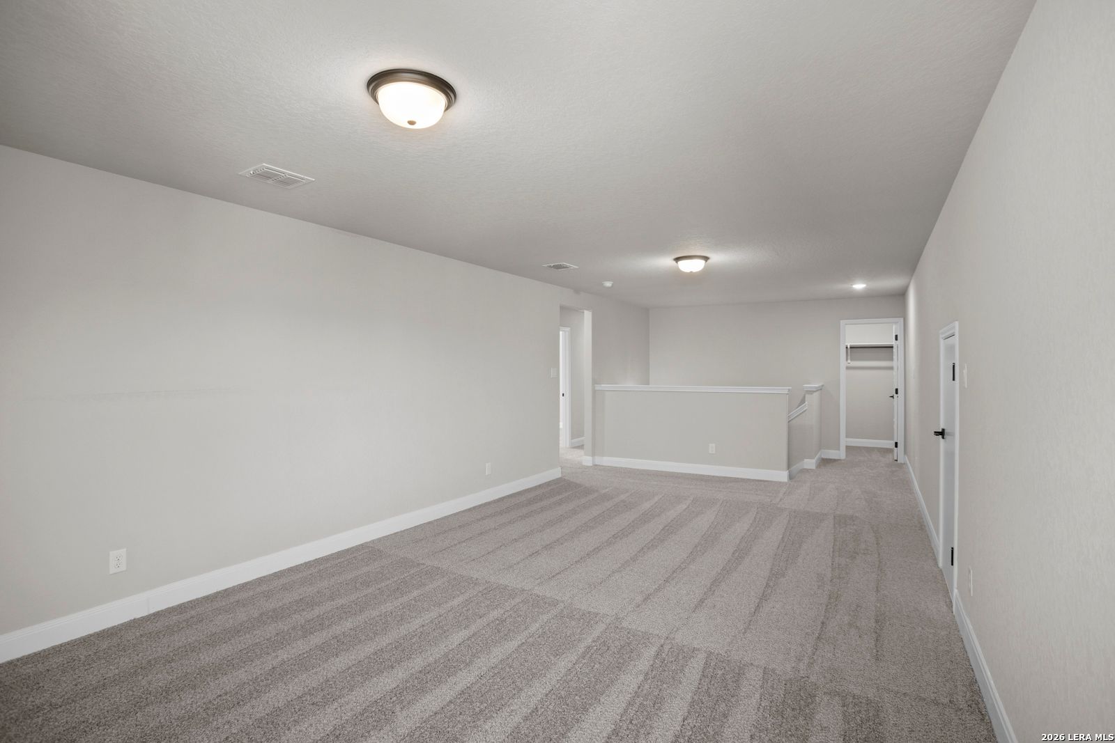 Spacious upstairs game room with plush carpeting in The Jennings G floor plan by Davidson Homes in Ladera, San Antonio.